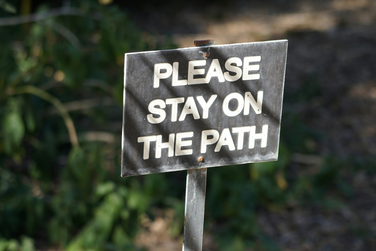 a sign that says please stay on the path